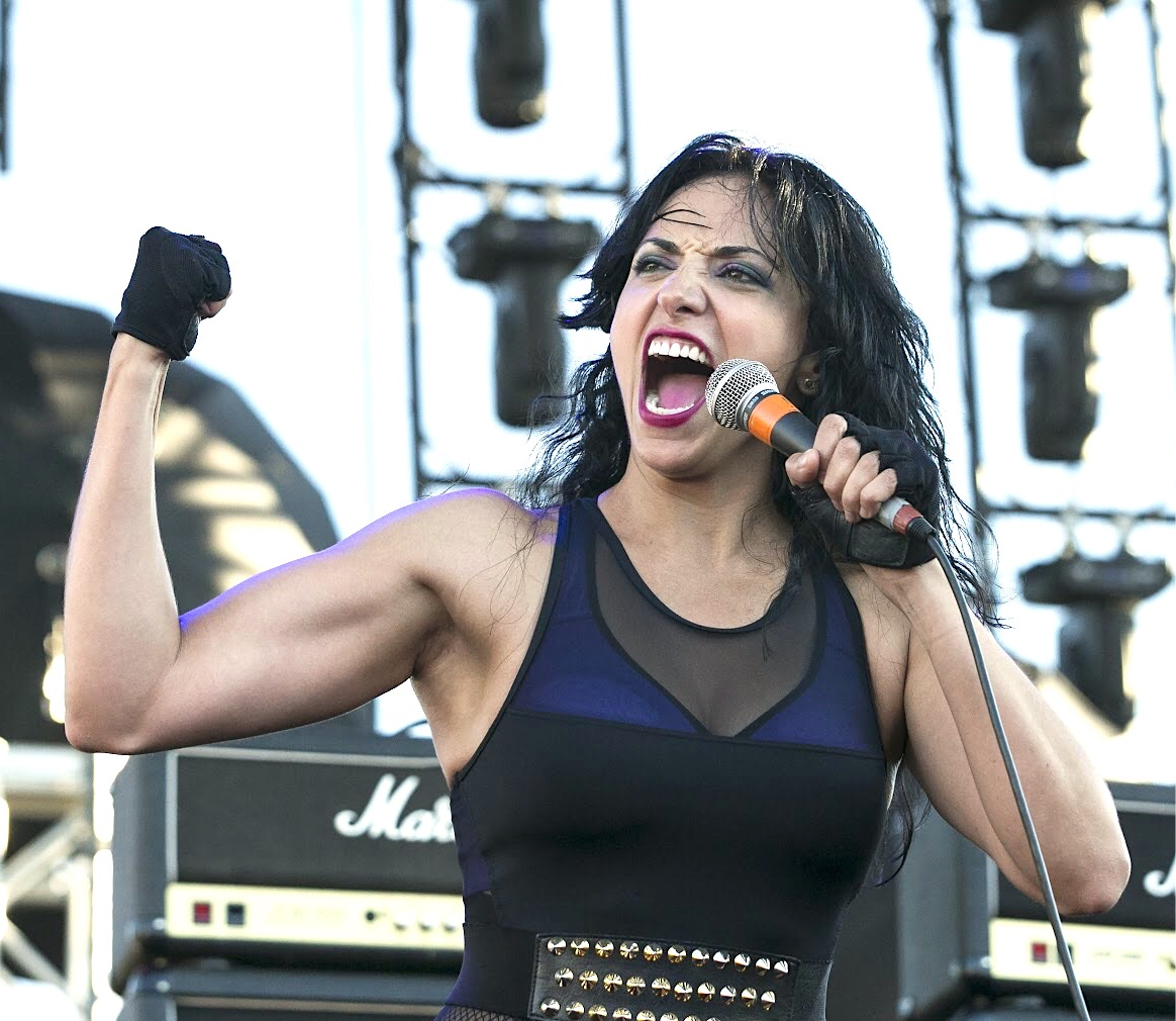 Singer passionately performing on stage with microphone.